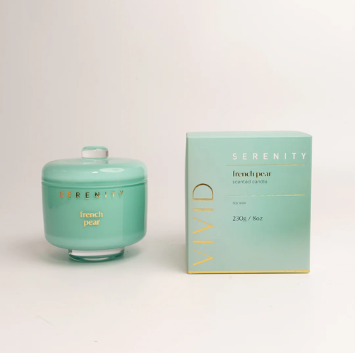 Mint green candle and packaging with 'Serenity' branding on a light gray background